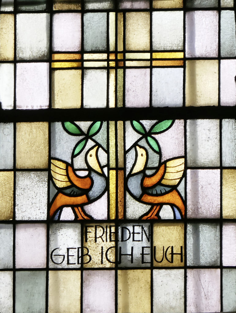 Und noch mal ein Friedensmotiv auf dem Titel: zwei Friedenstauben. Das Bild zeigt ein Fenster in der Kirche St. Hippolytus in Attendorn-­Helden.